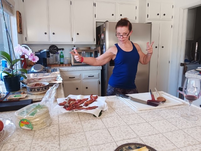 Stephanie, female, in the kitchen with thumbs up